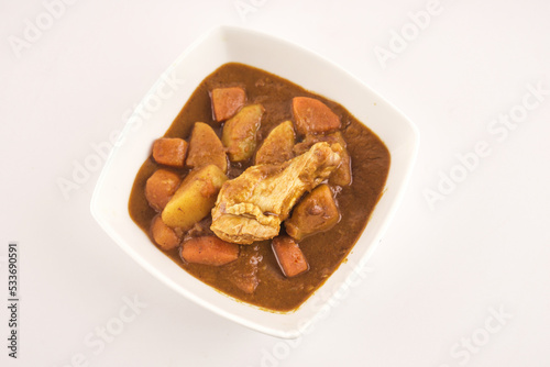 Chicken curry with potato on whitw background.  