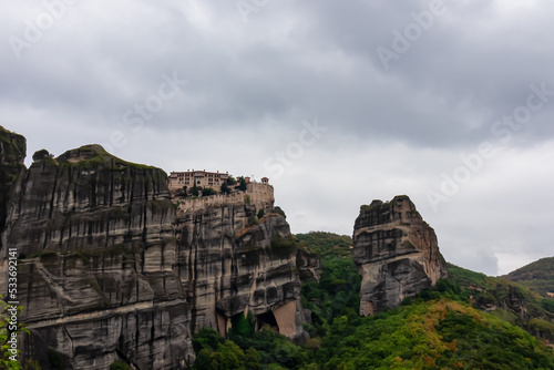 Scenic view of Holy Monastery of St Nicholas Anapafsas seen from forest on cloudy day, Kalambaka, Meteora, Thessaly, Greece, Europe. Dramatic landscape. Landmark build on unique rock formations