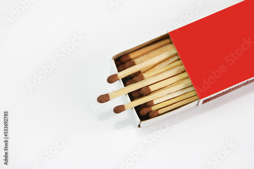 yellow wooden matches for lighting in a cardboard box on a white background