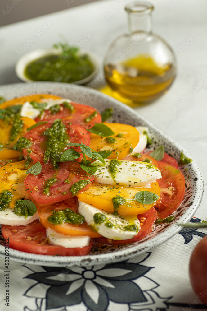 Close up of Caprese salad with yellow and red tomato on browm background. Italian cuisine. Close up of Caprese salad with yellow and red tomato on browm background. Italian cuisine.