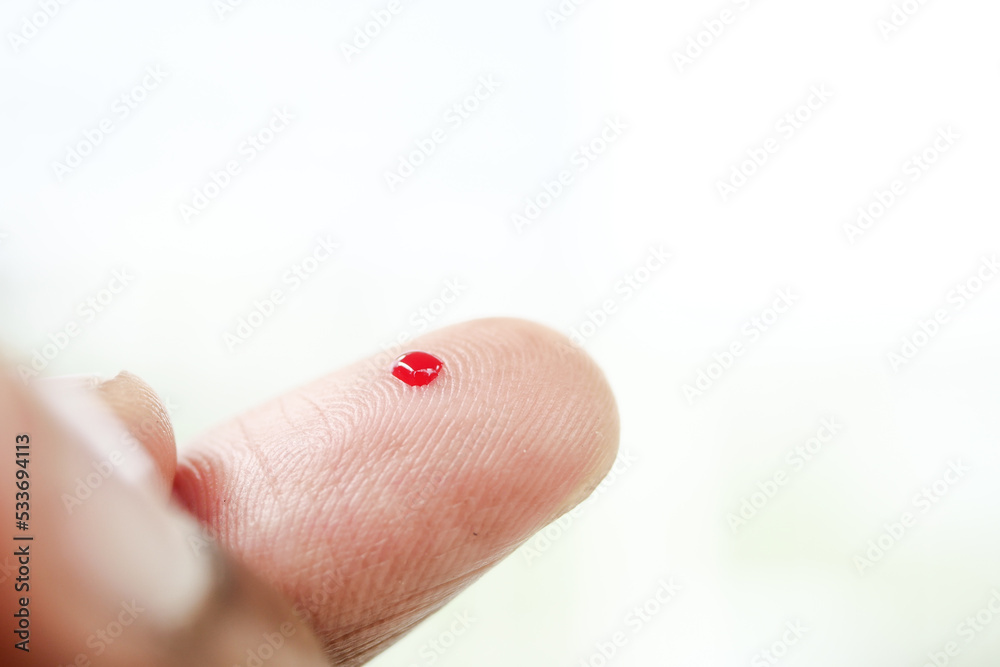 blood on finger, man's hand measuring blood sugar level blood on finger, man's hand measuring blood sugar level