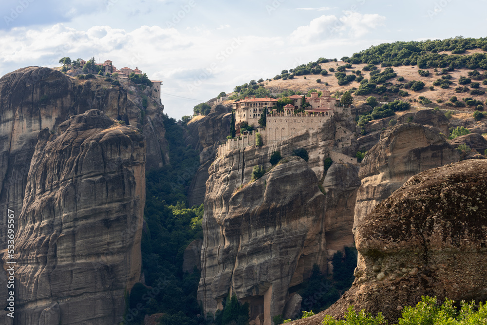 View from beneath up to hill top with Holy Varlaam monastery complex, Meteora, Greece.
