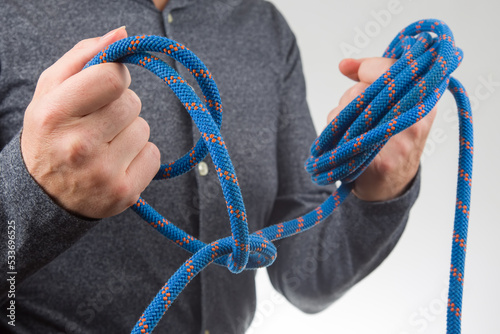 hand holds colored rope for climbing equipment. item for camping and climbing