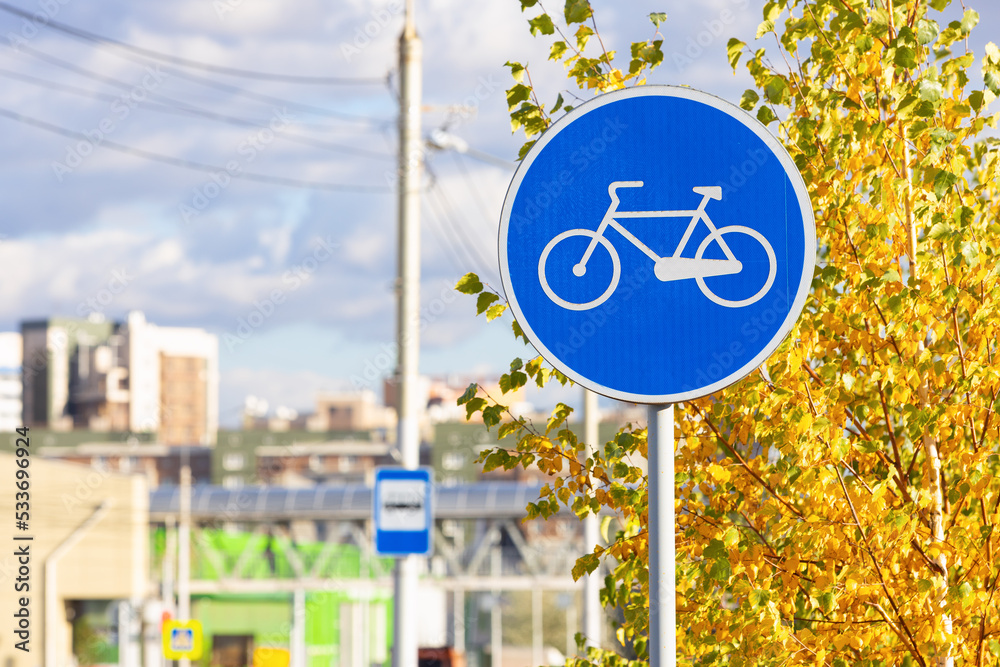 Blue road sign of a Bicycle lane on autumn urban street. Road sign Bicycle path
