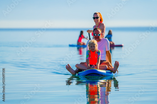 Happy Family on SUP stand up paddle on vacation.