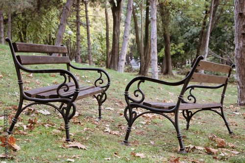 Two wooden benches opposite each other in autumn park
