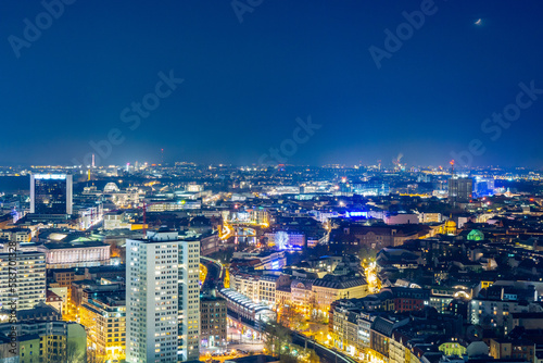 A dazzling nightscape of Berlin captured from above, where the city's heartbeat is visible through the vibrant interplay of lights, encapsulating the dynamic spirit of Germany's capital after dark.