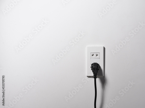 electrical socket and electrically cable on a white wall