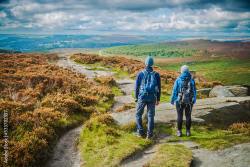 Hill walkers heading along Burbage edge in the peak District of the Derbyshire dales