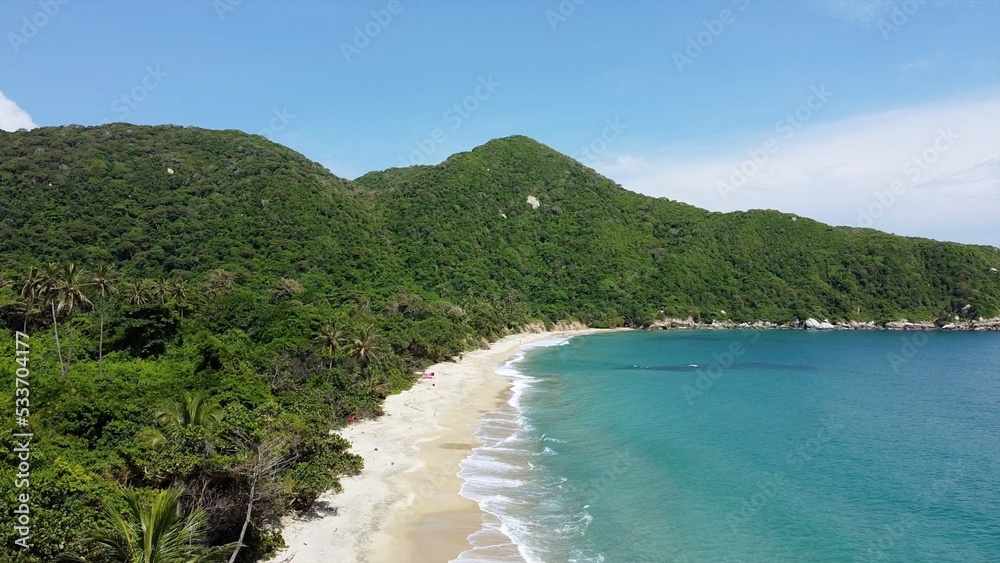 Santa Marta Colombia , Tayrona Natural Park Caribbean sea ocean - Drone aerial view of amazing  sand beach and  forest full of palm trees vegetation - deserted and paradise beach for summer vacation