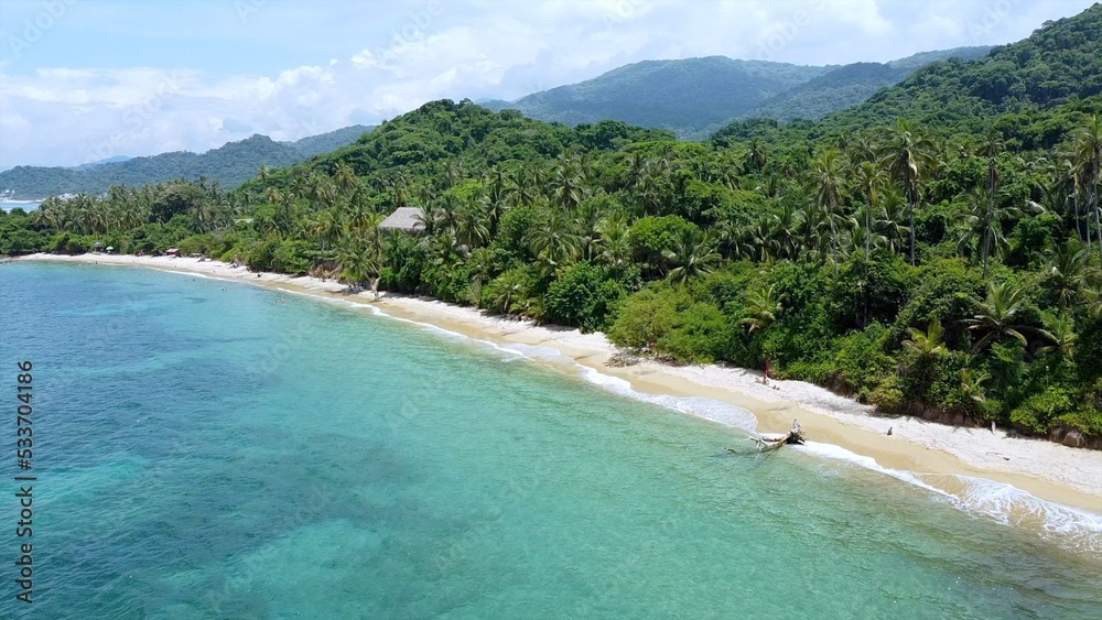 Fototapeta premium Santa Marta Colombia , Tayrona Natural Park Caribbean sea ocean - Drone aerial view of amazing sand beach and forest full of palm trees vegetation - deserted and paradise beach for summer vacation