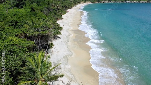 Santa Marta Colombia , Tayrona Natural Park Caribbean sea - Drone aerial view of amazing  desert sand beach and  forest - sea ​​level rise and beach decrease due to global warming and glaciers photo