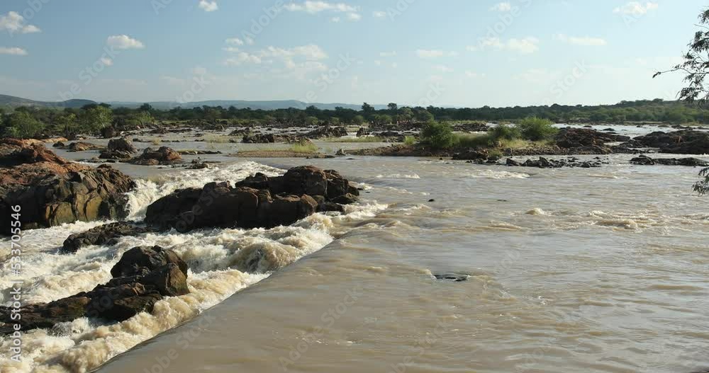 River on top of Beautiful Ruacana Falls on River Kunene in Northern Namibia on border with Angola, Africa wilderness landscape River on top of Beautiful Ruacana Falls on River Kunene in Northern Namibia on border with Angola, Africa wilderness landscape