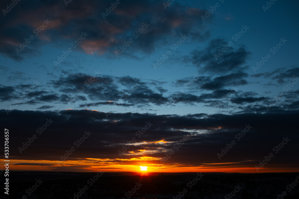 Beautiful landscape of sunset with dark colourful clouds. Natural abstract background.