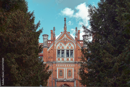 The facade of Lentvario Manor (Tiskeviciaus Manor) among the trees (foreground blurred) 