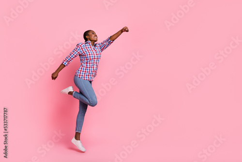 Full length profile photo of sportive active person raise hand fist jump fly empty space isolated on pink color background