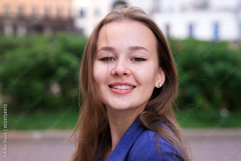 Close up portrait of European beautiful teen teenager girl, young happy attractive pretty woman at summer sunny day looking at camera and smiling outdoors