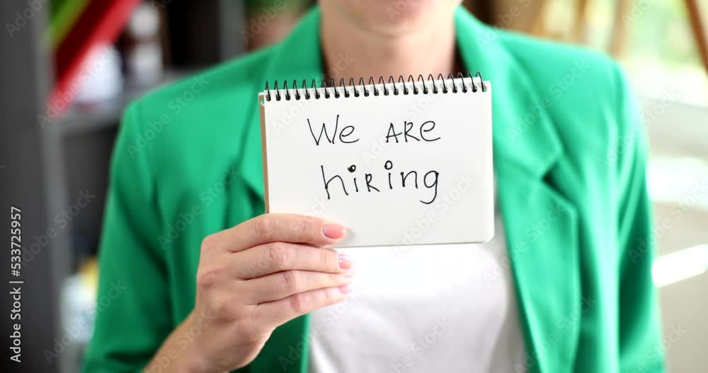 Businesswoman holding up with text we are hiring