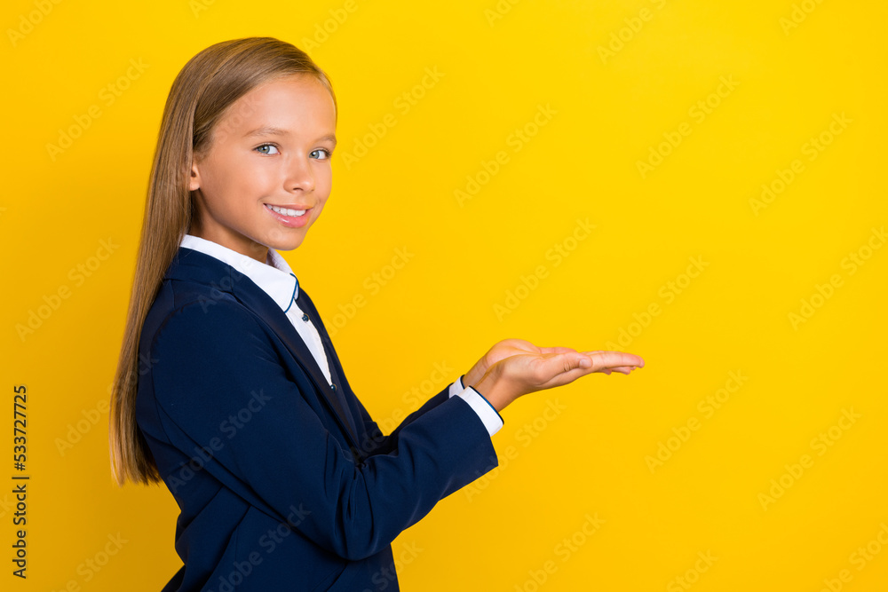 Profile side photo of pretty positive girl arm hold show cool product nice proposition empty space isolated on yellow color background Profile side photo of pretty positive girl arm hold show cool product nice proposition empty space isolated on yellow color background