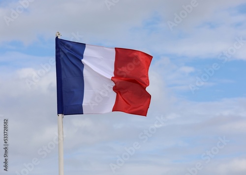 French Flag wavings on the blue sky without people