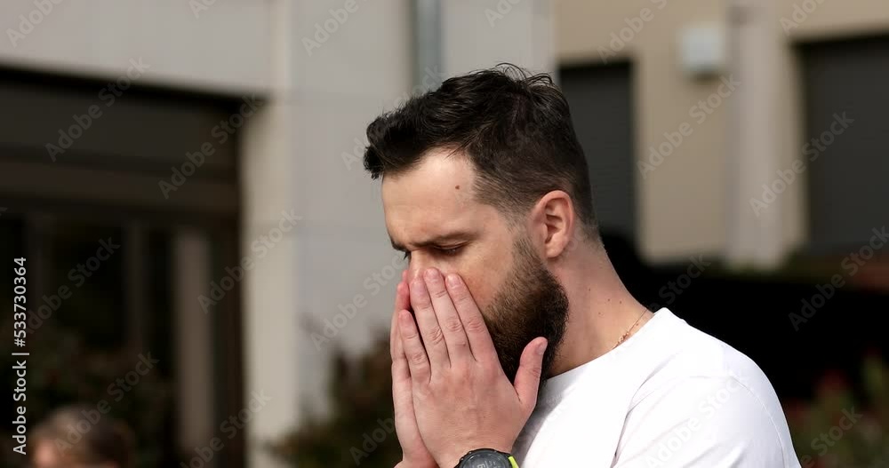 Man coughing or sneezing due to allergy standing in a park in spring or summer season. Man coughing or sneezing due to allergy standing in a park in spring or summer season.