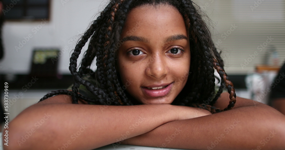 Preteen girl smiling at camera, mixed race black ethnicity. African
