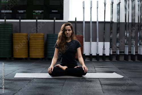 Young woman meditates, doing yoga poses and asana. Fitness girl enjoying yoga indoors.