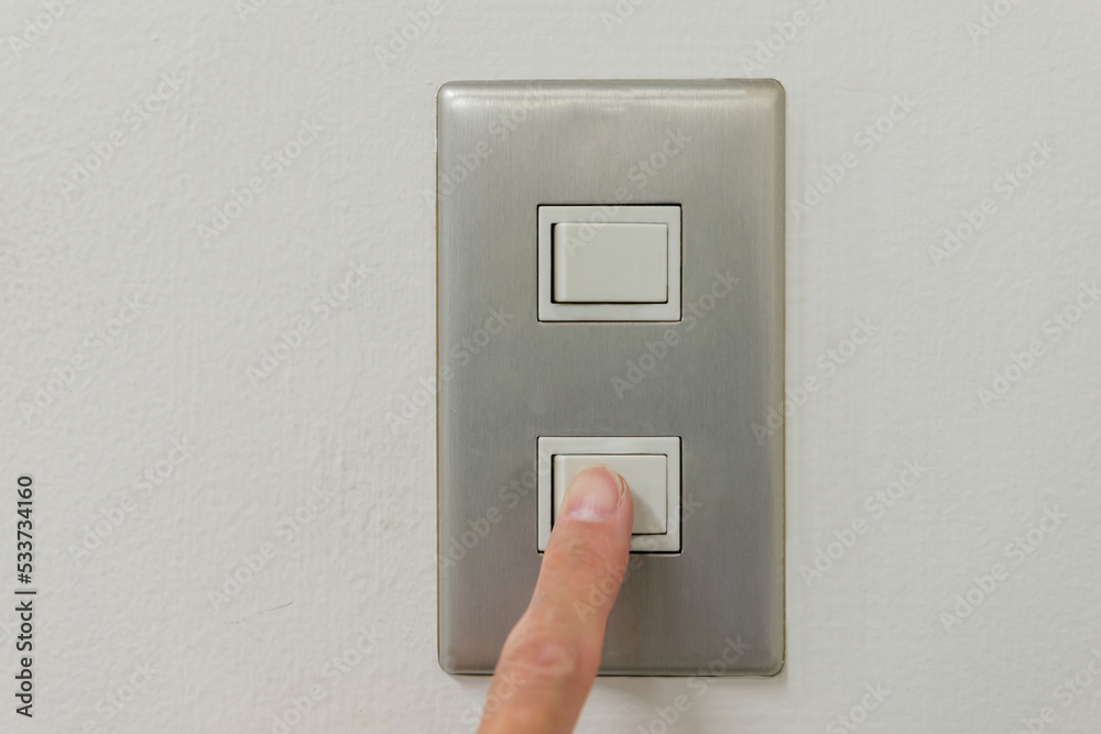 壁の電気のスイッチのボタンを人差し指で押す 壁の電気のスイッチのボタンを人差し指で押す
