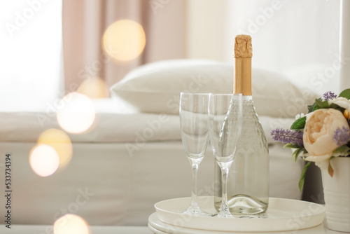 Two glasses and a bottle of champagne in a hotel room. Dating, romance, honeymoon, Valentine's day.