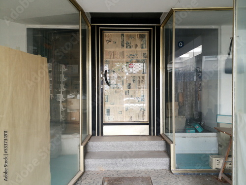 Mit Zeitung verklebte Ladentür eines geschlossenen Geschäft mit leerem Schaufenster in der trostlosen Innenstadt von Lage bei Detmold in Ostwestfalen-Lippe photo