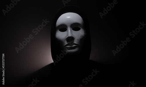Man wearing mask with hoodie on black background.