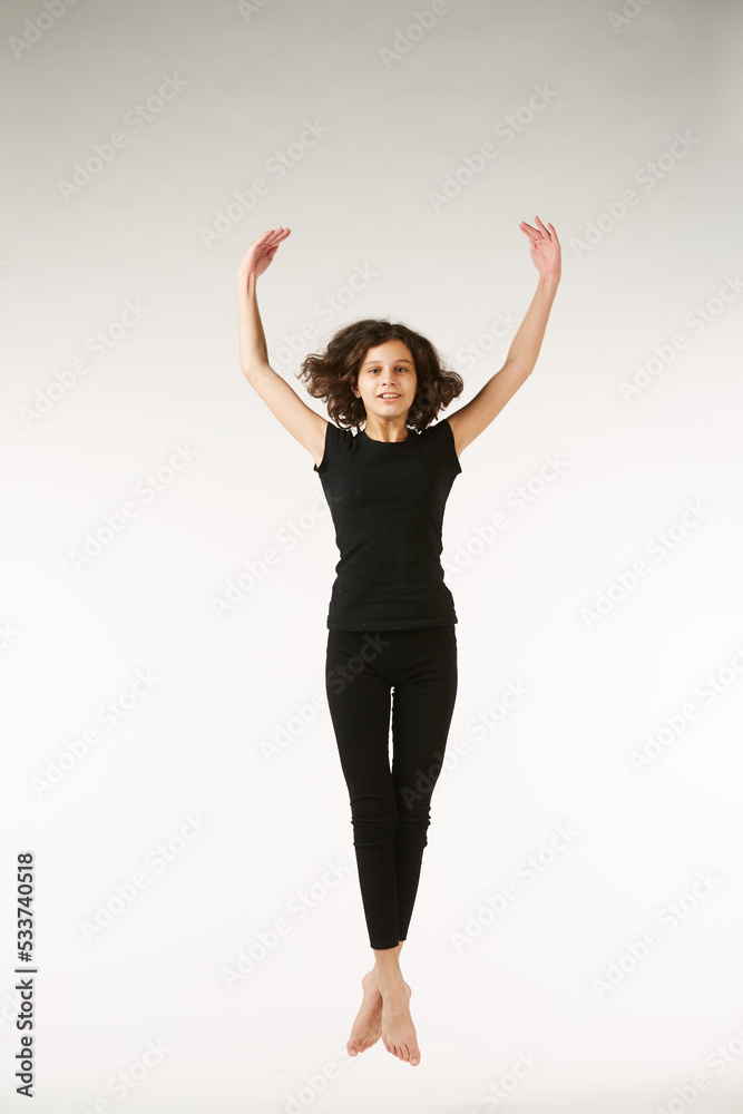 A girl in black clothes on a white isolated background performs dance and ballet poses and movements. A girl in black clothes on a white isolated background performs dance and ballet poses and movements.