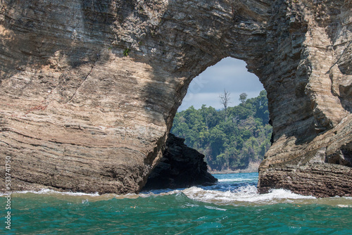 cliff with an arch on the shore photo