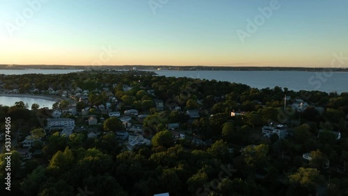 Aerial drone footage of Nahant, Massachusetts near Boston. Beautiful pink sky sunset on the Atlantic Ocean during summer. Waves on the rocky shoreline and Boston cityscape in the distance. photo