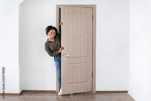 Cheerful Black Woman Opening Door Smiling Posing In New Home