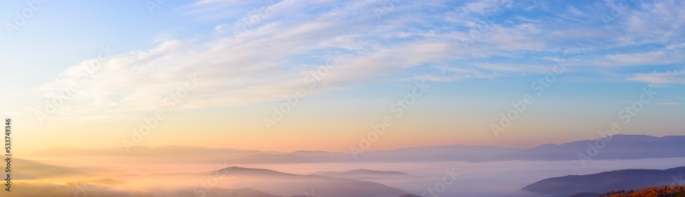 mountain landscape at sunrise in autumn season. rural valley full of glowing fog. beautiful nature scenery in morning light. gorgeous cirrus cloudscape above the distant ridge