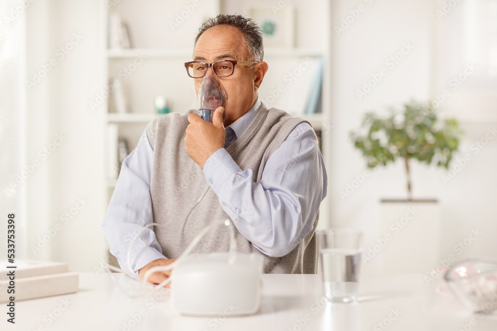 Mature man using a nebulizer Mature man using a nebulizer