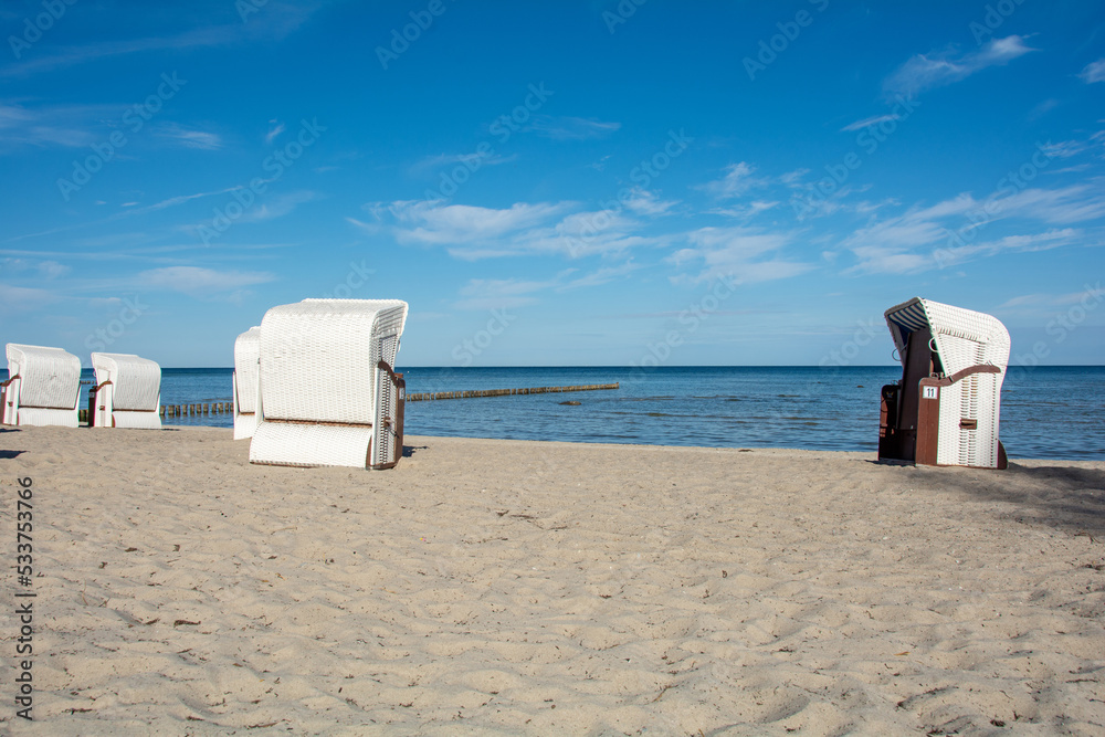 Wicker beach baskets  chairs on the beach at the Baltic Sea with groynes in the sea