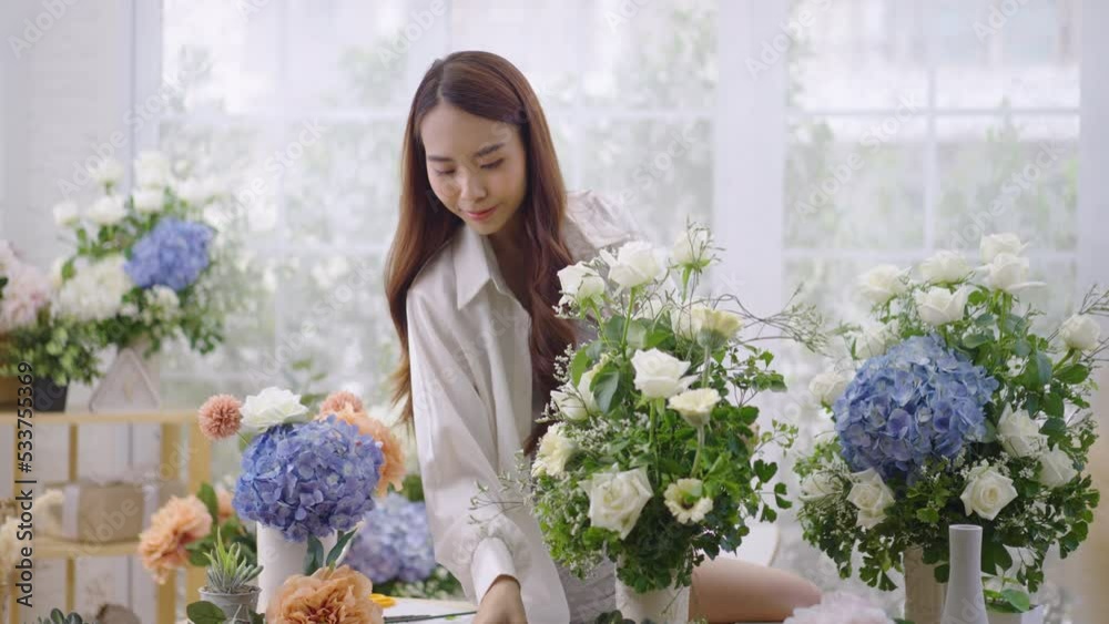 Asian women create lovely floral arrangements to sell. Asian women create lovely floral arrangements to sell.
