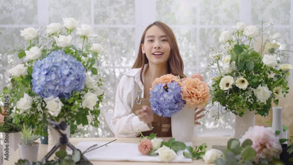 Young Asian woman does a live internet presentation for the sale of her flowers from her house. Young Asian woman does a live internet presentation for the sale of her flowers from her house.