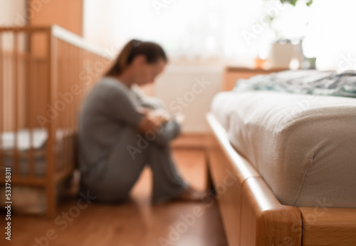 Tired, exhausted, mother, wife at home sitting on bedroom floor.	
