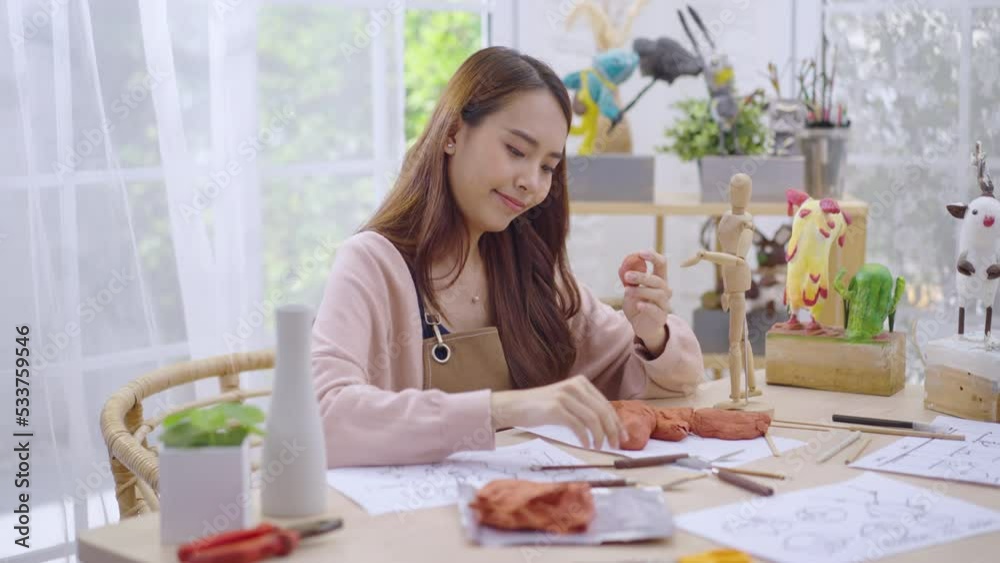 Young Asian girl making a sculpture with modeling clay at home .hobby clay sculpt concept Young Asian girl making a sculpture with modeling clay at home .hobby clay sculpt concept