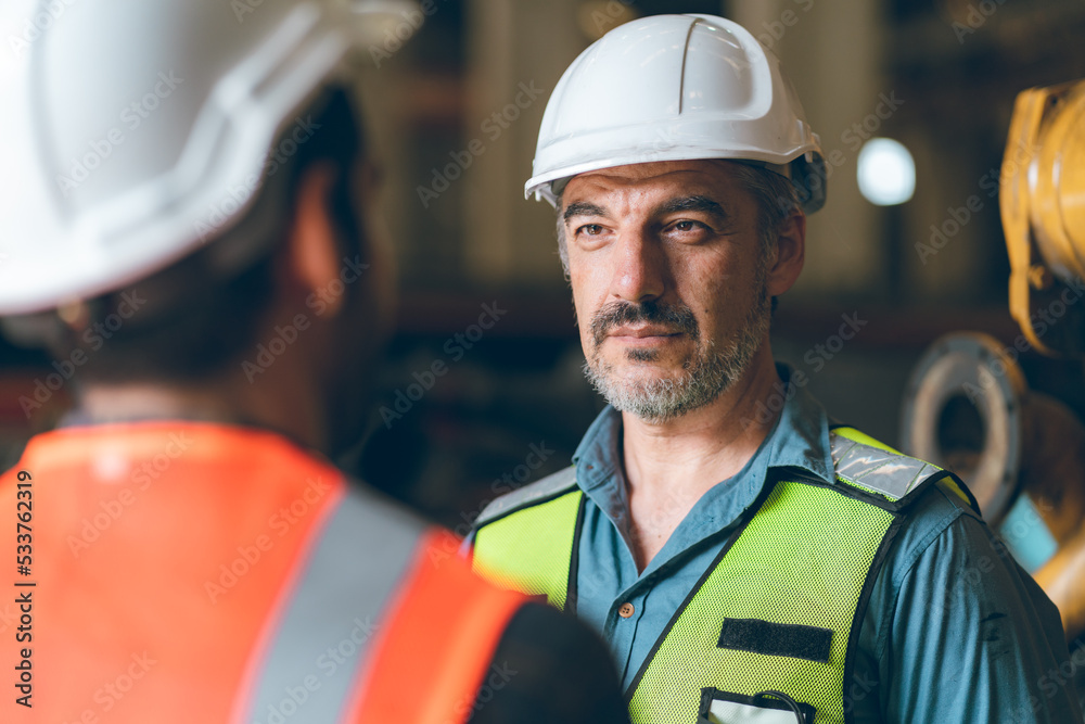 Obraz premium professional industrial engineers in hard hats. working at heavy industry manufacturing factory, man worker in an construction industrial job, maintenance service check for safety first concept