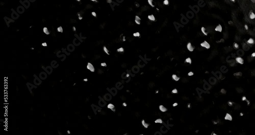 Water vibrating strongly from sund creating patterns. Cymatics science effect crates soundwaves demonstrates the energy of sound in a physics lab. Geometry of sound and resonance. Black background 4k