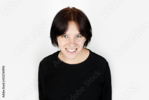 A beautiful smile and healthy white teeth of a young teenage girl on a light background, the girl is smiling, she has short burgundy hair and a nose piercing © Мар'ян Філь