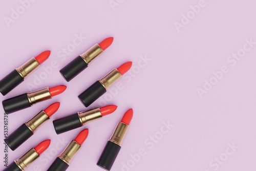 several tubes of red lipstick on a pink pastel background. copy paste, copy space. 3D render