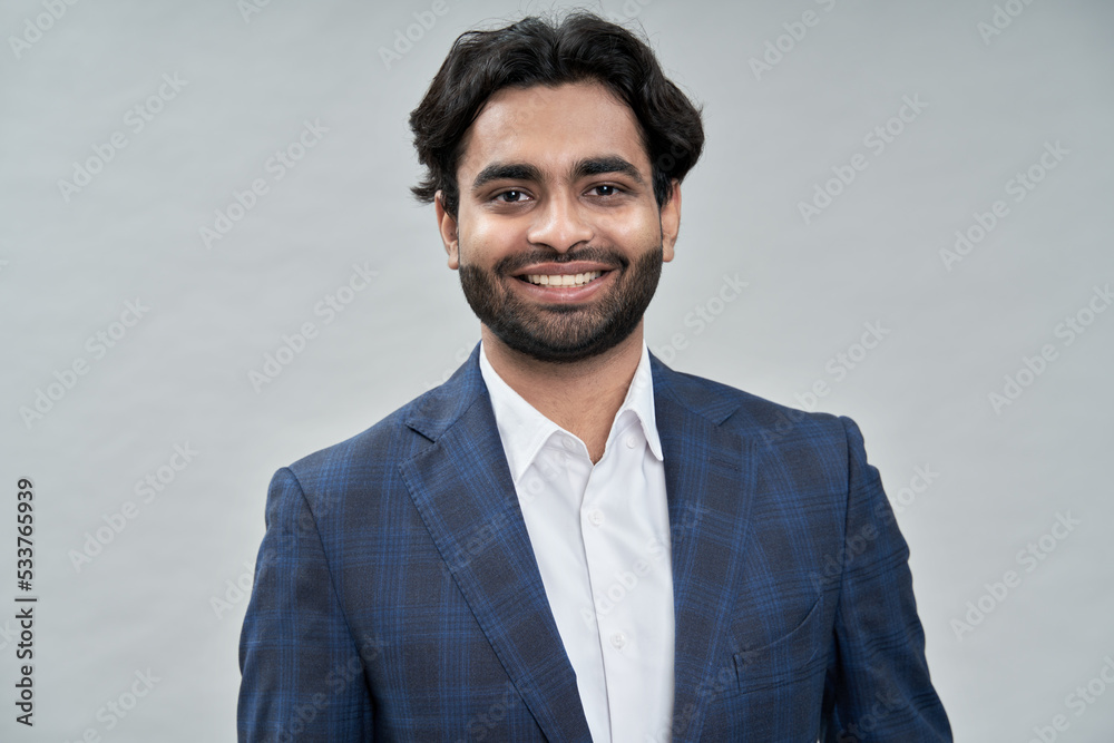 Happy young indian business man ceo leader, arab professional manager,  smiling expert businessman executive wearing suit looking at camera  isolated on beige, close up headshot portrait. Stock Photo