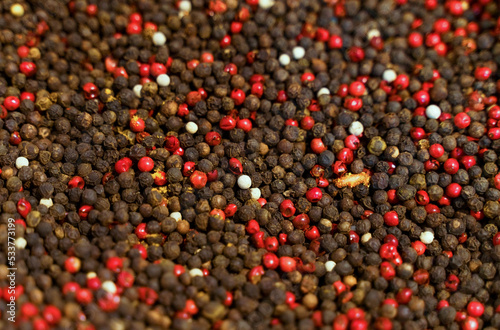 Black, white and red peppercorns on a market stall.