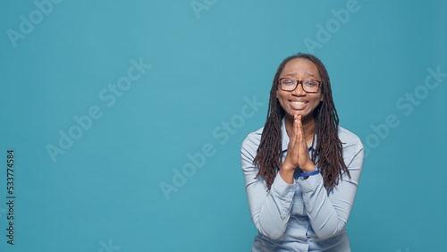 Fotografiet African american model doing prayer hands on camera, begging and asking for good luck and fortune