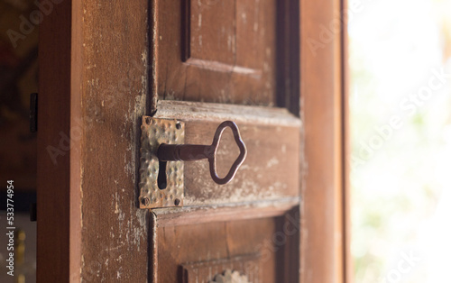 Old wooden weathered door, with antique brass key